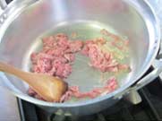 干し椎茸と豚肉、しめじ、にんじんをサラダ油で炒めている写真