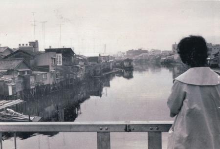 女性が橋の上から景色を眺めている写真