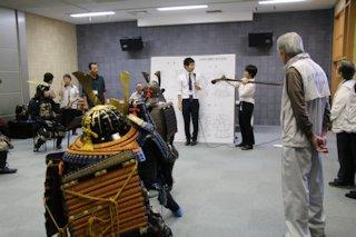 火縄銃の仕組みについて学ぶ人達の写真