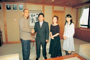 原市長と握手をする犬童監督、宮本信子さん、黒瀬真奈美さんの写真
