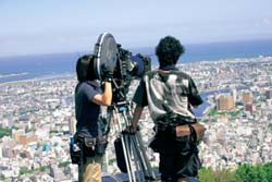 眉山山頂から徳島市内を撮影するスタッフの様子の写真