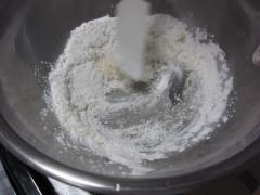 米粉、サラダ油、砂糖、塩を加えて混ぜている写真