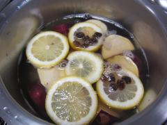 さつまいもと水をひたひたに入れた鍋に砂糖、レモン、レーズンを入れている写真