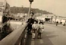 昔の新町橋の上で母親と子ども3人がこちらを向いて写っている写真